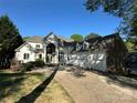 A stunning two-story home with stone and white exterior, features a three-car garage and arched entry at 5517 Mountain Point Ln, Charlotte, NC 28216