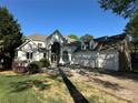 A stunning two-story home with stone and white exterior, features a three-car garage and arched entry at 5517 Mountain Point Ln, Charlotte, NC 28216