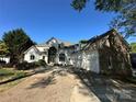 A stunning two-story home with stone and white exterior, features a three-car garage and arched entry at 5517 Mountain Point Ln, Charlotte, NC 28216