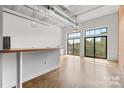 Open living area with concrete floors, large windows, and a cozy breakfast bar overlooking neighborhood views at 626 N Graham St # 405, Charlotte, NC 28202