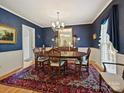 Elegant dining room featuring dark blue walls, classic furniture, and a decorative rug at 6420 Saint John Ln, Charlotte, NC 28210