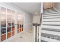 Inviting foyer with tiled floors, staircase, and glass paned doors leading to living space at 6634 Rocky Falls Rd, Charlotte, NC 28211