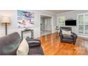 Comfortable living room with hardwood floors, wainscoting, and ample natural light at 6634 Rocky Falls Rd, Charlotte, NC 28211