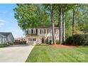 Traditional two-story home with red shutters and lush landscaping, framed by mature trees at 7220 Spring Morning Ln, Charlotte, NC 28227