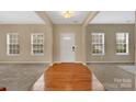Bright and open foyer with hardwood floors transitioning to carpet, illuminated by natural light from the large windows at 7362 Waterwheel Sw St # 280, Concord, NC 28025