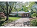 Beautiful brick home with a green door, mature trees, and a lovely front yard at 821 Mark St, Belmont, NC 28012