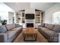 Inviting living room features a cozy fireplace, custom built-ins, and neutral-toned sofas at 8271 Camelia Ln, Denver, NC 28037