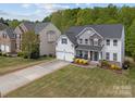 Aerial view of a well-maintained home with a lush green lawn and a long driveway at 8453 Mossy Cup Trl, Harrisburg, NC 28075