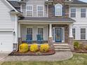 Charming front porch with rocking chairs and a decorative glass front door at 8453 Mossy Cup Trl, Harrisburg, NC 28075