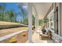 Inviting covered porch with seating, perfect for relaxing and enjoying the surrounding landscape at 1033 Harrogate Dr, Bessemer City, NC 28016