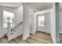 Bright foyer with wood-look flooring, staircase, and a white front door at 107 Maurice St, Monroe, NC 28112