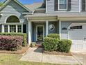 Inviting front porch with well-maintained landscaping and unique circular window accents at 12100 Bay Tree Way, Charlotte, NC 28277
