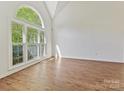 Sunlit living room featuring hardwood floors and large arched windows at 12100 Bay Tree Way, Charlotte, NC 28277