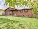 Lovely brick home with a covered porch, rocking chairs, and a beautifully manicured lawn at 1315 Holshouser Rd, Rockwell, NC 28138