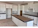 Spacious kitchen featuring white cabinets, a large center island, and a stylish tile backsplash at 13304 Chopin Ridge Dr, Huntersville, NC 28078
