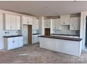 Spacious kitchen with white cabinets, a center island, and light-colored flooring at 13304 Chopin Ridge Dr, Huntersville, NC 28078