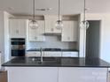 The spacious kitchen features stainless steel appliances, an island, and globe pendant lighting at 13304 Chopin Ridge Dr, Huntersville, NC 28078