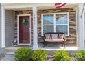 Inviting front porch with stone details, a bench, and a welcoming front door at 1347 Mifflin Ln, Dallas, NC 28034