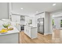 Modern kitchen with stainless steel appliances, white cabinets, and an island with quartz countertops at 143 Ross Rd, Mooresville, NC 28117