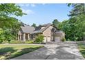 Spacious brick home featuring a three-car garage and a long driveway at 15210 Pavilion Valley Cir, Huntersville, NC 28078