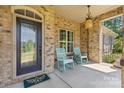 Welcoming front porch featuring rocking chairs, a decorative door, and brick accents at 15210 Pavilion Valley Cir, Huntersville, NC 28078