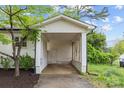 View of the carport with white support columns and decorative lattice at 1601 Gambia St, Charlotte, NC 28208
