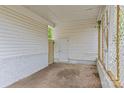 Carport interior featuring white walls, lattice accents, and a concrete floor at 1601 Gambia St, Charlotte, NC 28208