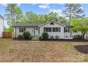 Charming home featuring a light blue front door, black shutters, and landscaped yard at 1601 Gambia St, Charlotte, NC 28208