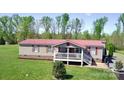Single-story home featuring a red roof and inviting front porch, nestled within a vast green lawn at 161 Hickory Nut Dr, Statesville, NC 28677