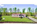 Single-story home featuring a red roof and inviting front porch, set within a vast, well-manicured lawn at 161 Hickory Nut Dr, Statesville, NC 28677