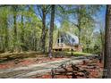 A-frame home with mature trees, wooden fence, and a gravel driveway at 1680 Ne 17Th Avenue Ct, Hickory, NC 28601