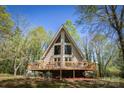 Lovely A-frame home featuring a large wooden deck, surrounded by lush trees at 1680 Ne 17Th Avenue Ct, Hickory, NC 28601