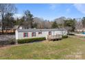 Cozy single-story home with red shutters, a front porch, and a spacious green lawn at 189 Woodwinds Dr, Mooresville, NC 28115