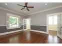 Bright living room with hardwood floors, multiple windows, and stylish French doors at 2015 Dilworth E Rd, Charlotte, NC 28203