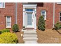 Close-up of the townhome's entrance with a glass-paneled front door and manicured shrubs at 2638 Dilworth Heights Ln, Charlotte, NC 28209