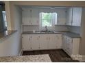 Cozy kitchen featuring white cabinetry, granite countertops, a stainless steel sink, and a window view at 301 E 11Th St, Kannapolis, NC 28083