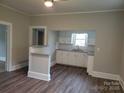 Spacious open living room with laminate flooring connecting to the kitchen featuring white cabinets at 301 E 11Th St, Kannapolis, NC 28083