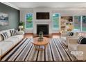 Bright living room with a cozy fireplace, stylish furniture, and seamless access to the outdoor area at 305 Augustus Ln, Mount Holly, NC 28120