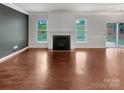 Clean, spacious living room with a fireplace and hardwood floors, offering a blank canvas for customization at 305 Augustus Ln, Mount Holly, NC 28120
