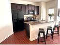 Stylish kitchen boasting a central island with seating, dark cabinetry, and stainless steel appliances at 3623 Danvers St, Charlotte, NC 28213