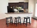 Modern kitchen featuring dark cabinetry, a peninsula with seating, and stainless steel appliances at 3623 Danvers St, Charlotte, NC 28213