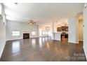 Open-concept living room with a fireplace, hardwood floors, and ample natural light, perfect for entertaining and relaxation at 609 Kahana River Rd, Fort Mill, SC 29715