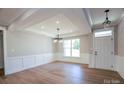 An open dining room features modern lighting, hardwood floors, and white wainscoting at Tbd Boomer Ct # 10, Statesville, NC 28677