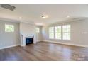 A cozy living room with a fireplace, large windows, and hardwood flooring at Tbd Boomer Ct # 10, Statesville, NC 28677