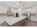 Modern kitchen featuring white cabinets, stainless steel appliances, and a large island at Tbd Boomer Ct # 13, Statesville, NC 28677