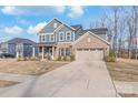 Charming two-story home with a combination of blue siding and brick, and an attached two-car garage at 1043 Kalli Dr, Matthews, NC 28104