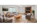 Cozy living room with brick fireplace, ceiling fan, and plush seating for comfortable living at 111 Pine Grove Church Rd, Concord, NC 28025