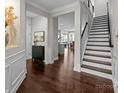 Inviting entryway with dark hardwood floors, staircase, and open view to the kitchen at 11227 Whimbrel Ct, Charlotte, NC 28278