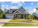 Beautiful home with a stone facade, manicured lawn, and attached two-car garage on a sunny day at 11227 Whimbrel Ct, Charlotte, NC 28278
