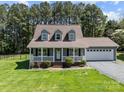 Charming home featuring a welcoming front porch and a well-maintained landscaped yard at 1228 Swift Rd, Oakboro, NC 28129